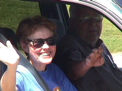 Shirley and Bill wave from Shirley's car