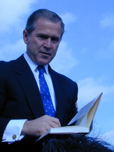 George W. Bush autographs a book